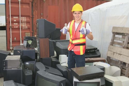 Skip hire vehicle at a site, safety cones and staff preparing for rubbish collection