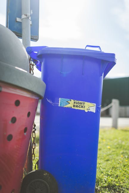 A black wheeled rubbish bin with a white label and the words